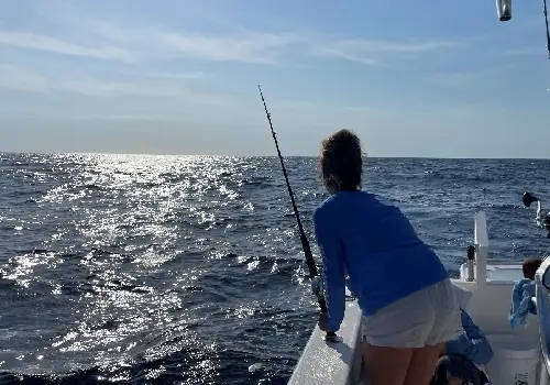 Fisherperson reeling in a fish during Deep-Sea Fishing in St. Petersburg FL