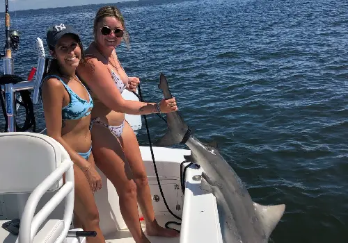 Two women showing off the shark they caught during Fishing Trips in St. Petersburg FL